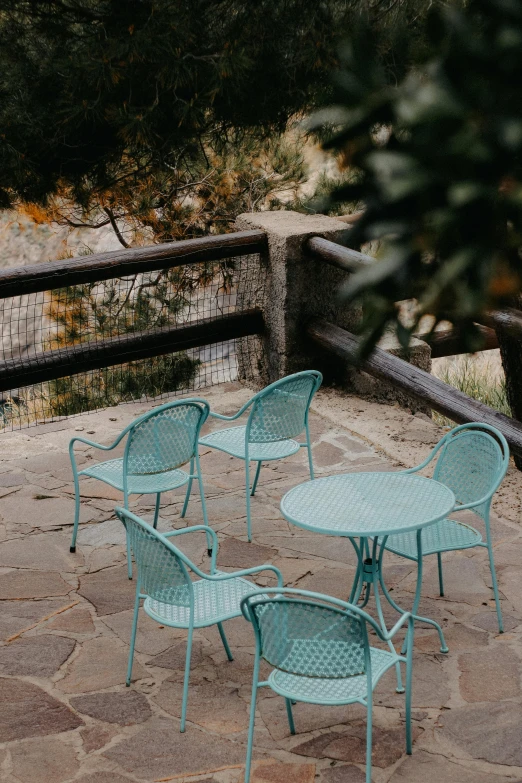 four blue chairs and one table in an outdoor seating area