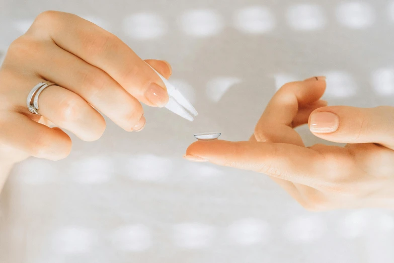 two women holding onto the tip of small toothbrushes