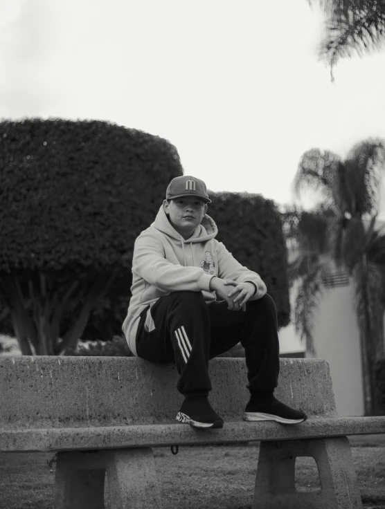 a man sitting on a bench with his arms folded and looking to his left