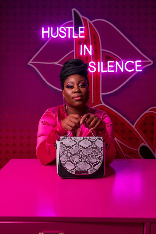 a lady sitting at a pink desk posing for the camera