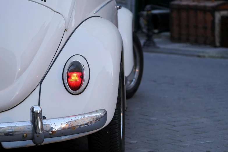 an old vw beetle is shown with red lights