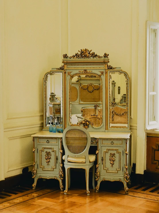 a room with a chair, a desk and an ornate dresser
