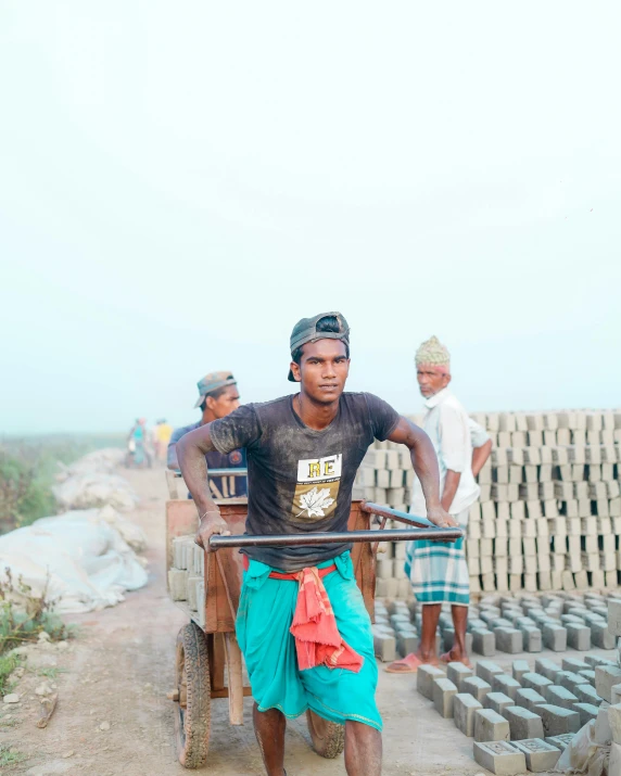 a man standing in front of bricks being stacked into a cart