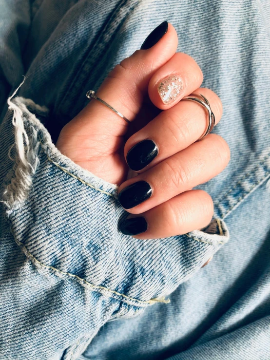 a woman's hands with some tattoos and rings