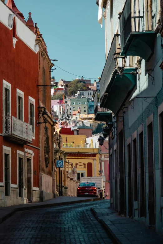 an empty cobblestone street with parked cars