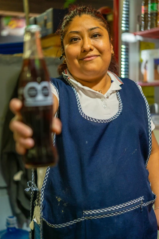 a woman is holding up an odd shaped beer