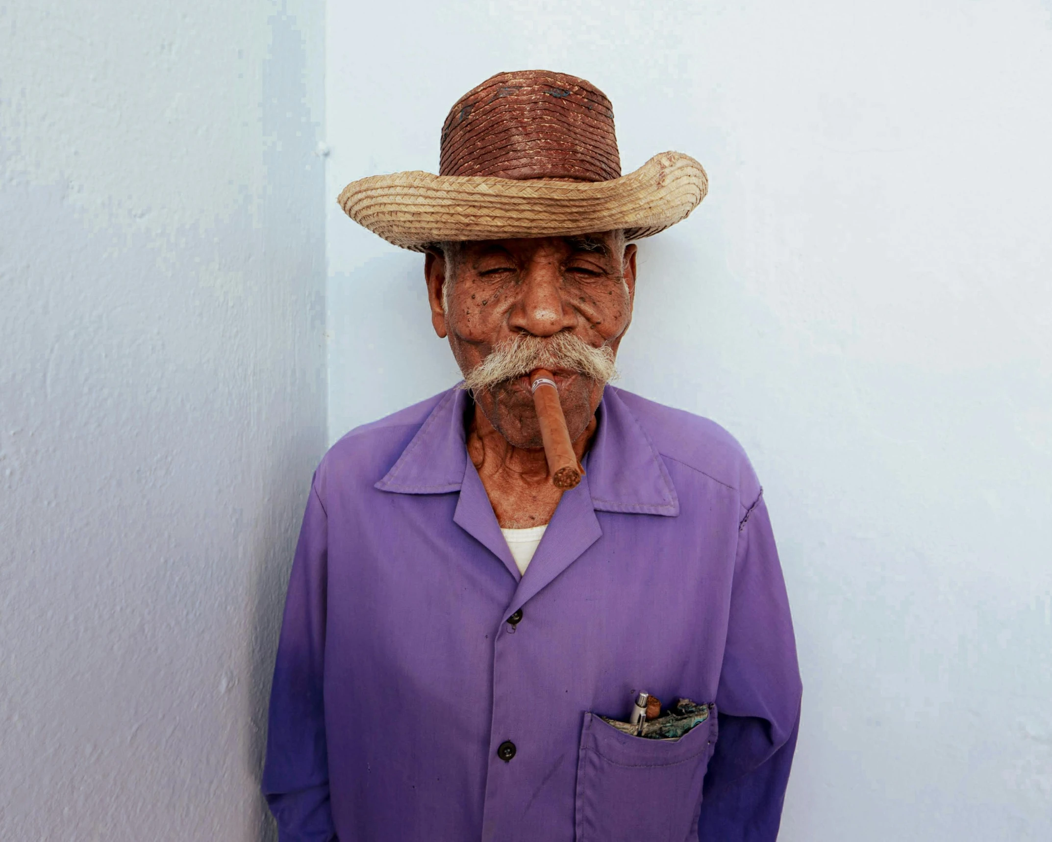 an old man with a large straw hat and pipe