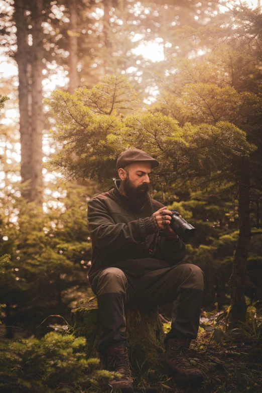 a man with a beard sitting on top of a tree stump