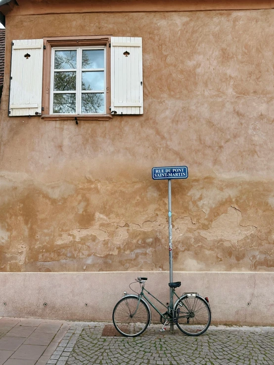 a bike leans against the corner of an old building