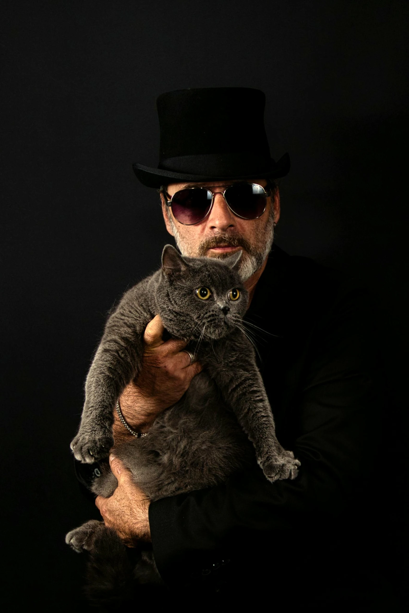 a man holds a cat with a top hat