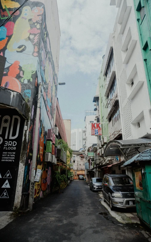 a wide open street with parked cars near buildings