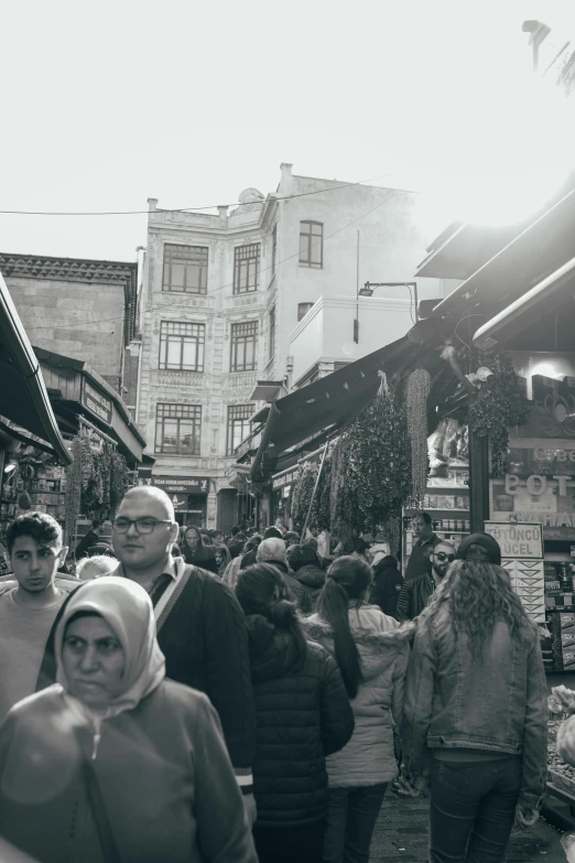 a black and white image of people walking in the street