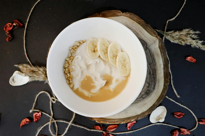 the bowl of oatmeal is surrounded by slices of bananas