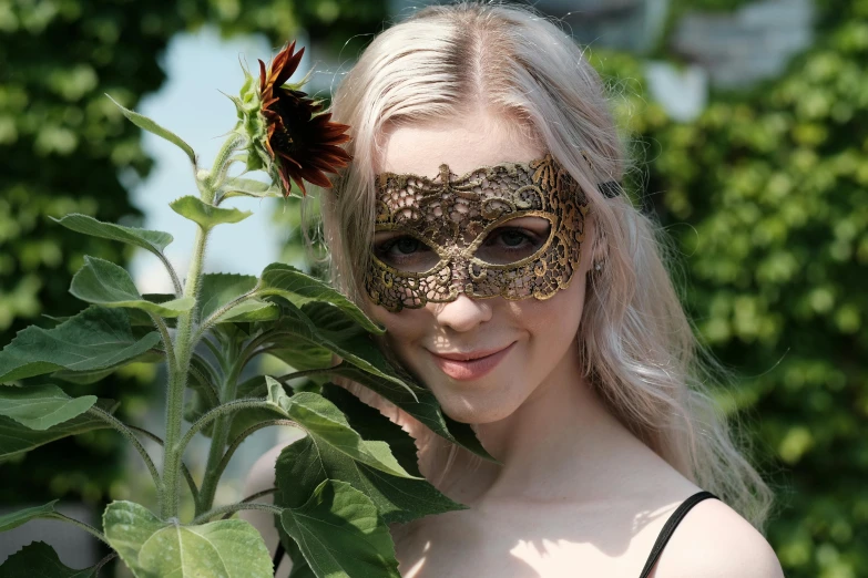 a woman with long blonde hair wearing a fancy mask