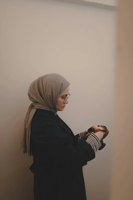 a woman standing in a corner with her hand on her fingers