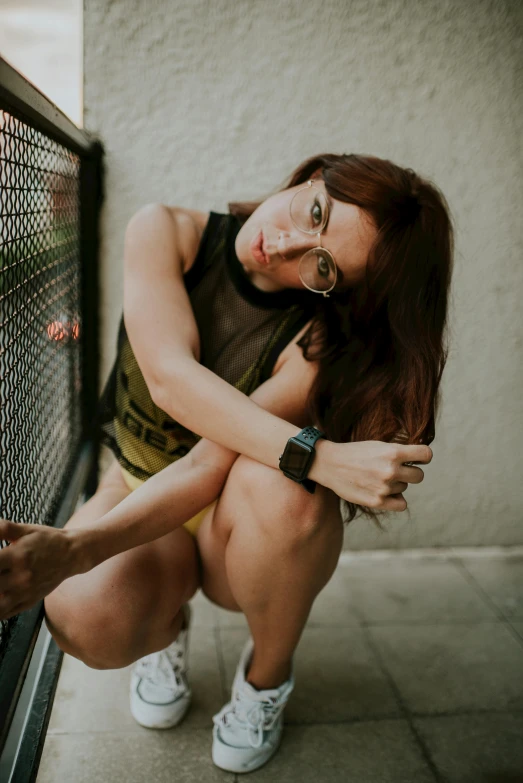 a woman is posing next to a metal fence