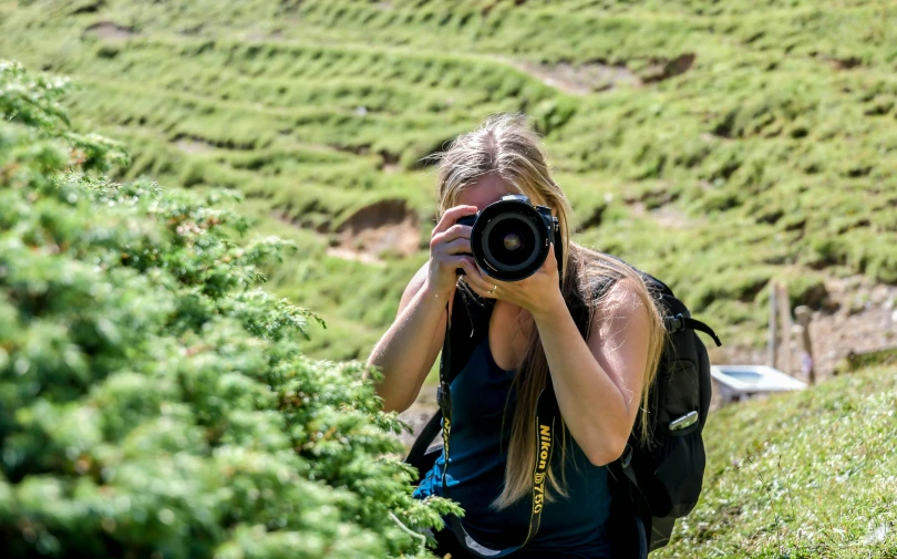 a woman is taking pictures of plants in the distance