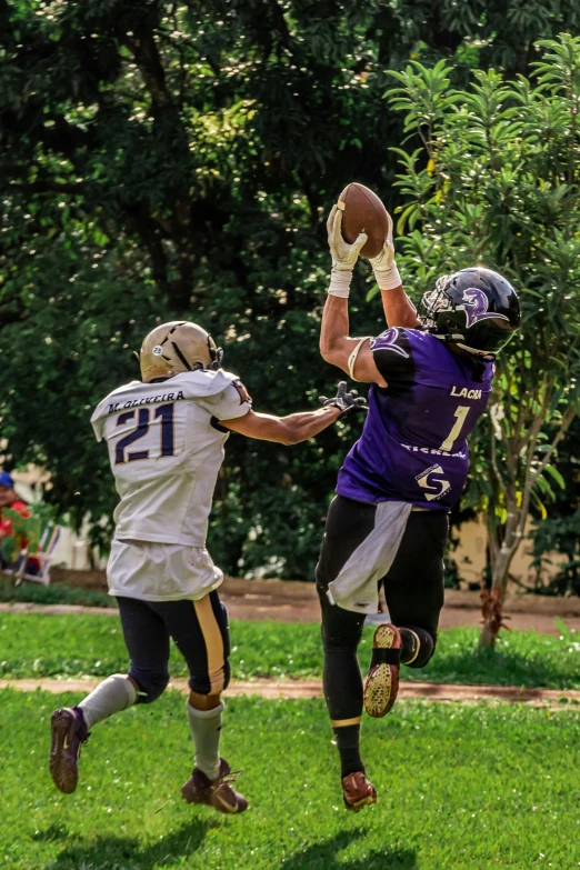 two football players who are about to grab a football