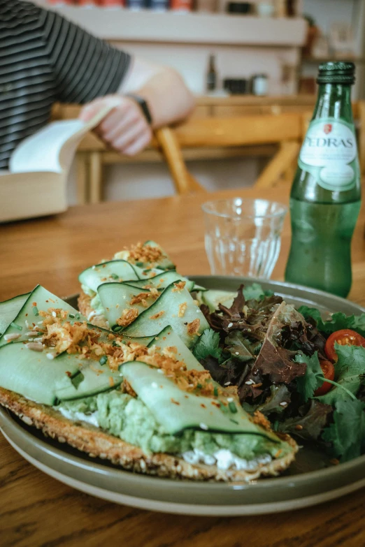 a person sits at a wooden table with a plate of food