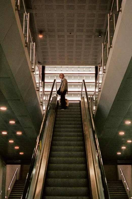 a man with a suitcase is walking up an escalator