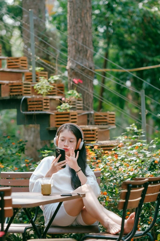 a woman is sitting on a wooden bench while talking on her phone