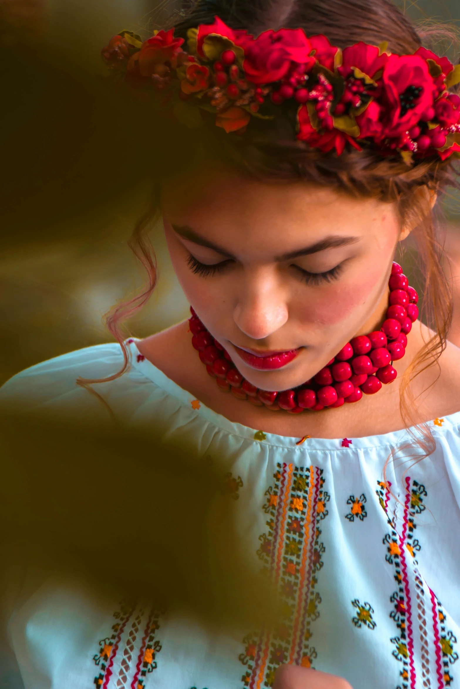 a girl is wearing a red necklace and matching celets