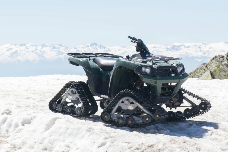 a four - wheeler is parked on top of snow in the mountains