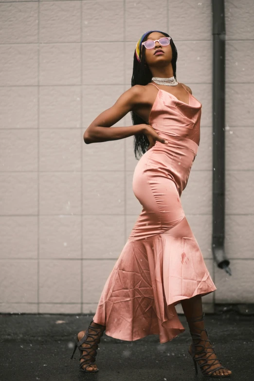 a woman poses in a pink dress