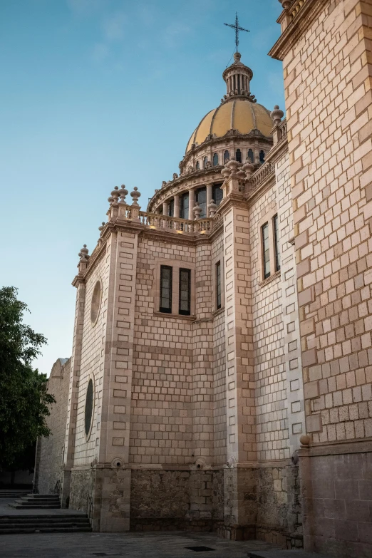 a small church with a gold dome next to a brick wall