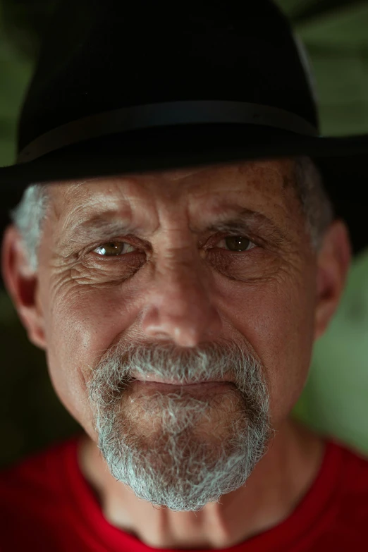 an old man with a white beard and wearing a black hat