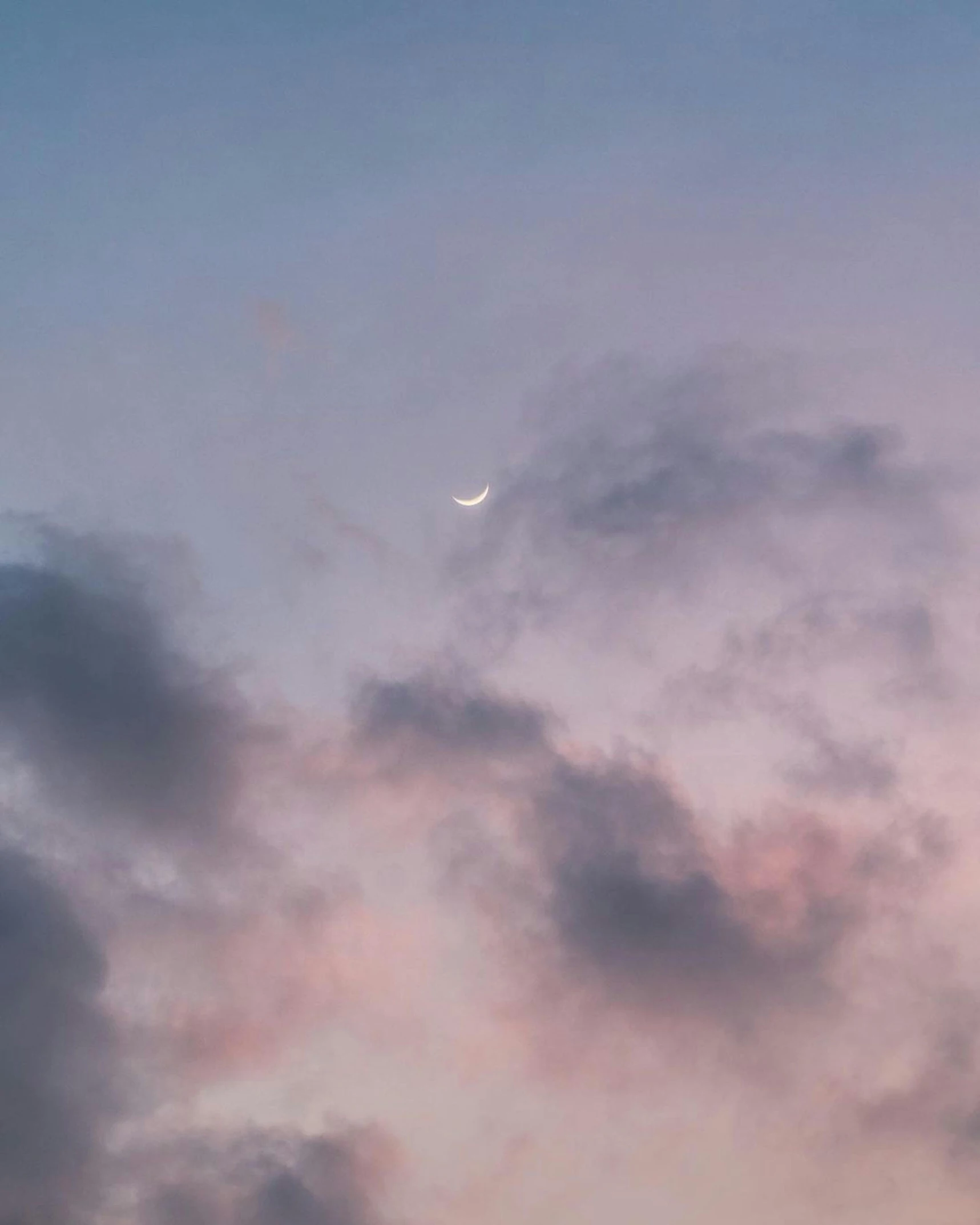 an airplane with the moon in the cloudy sky