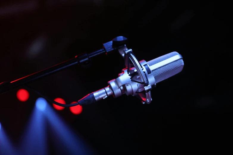 a microphone with light blue lights coming from it and on top