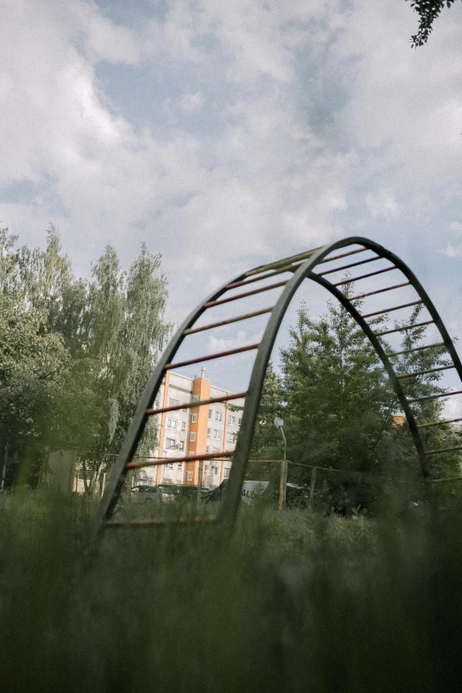 a very long metal arched bridge over some trees