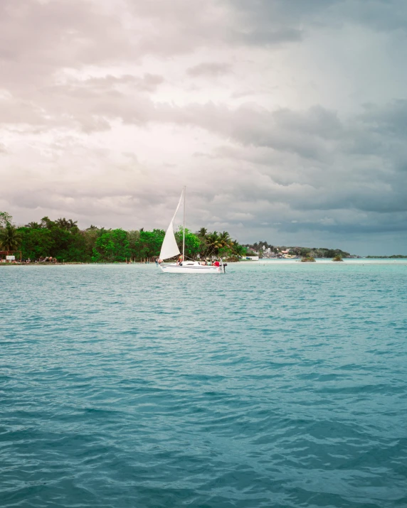 a lone boat in the water and some clouds in the background