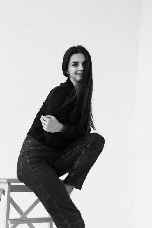 a woman is sitting on a chair in a black and white po