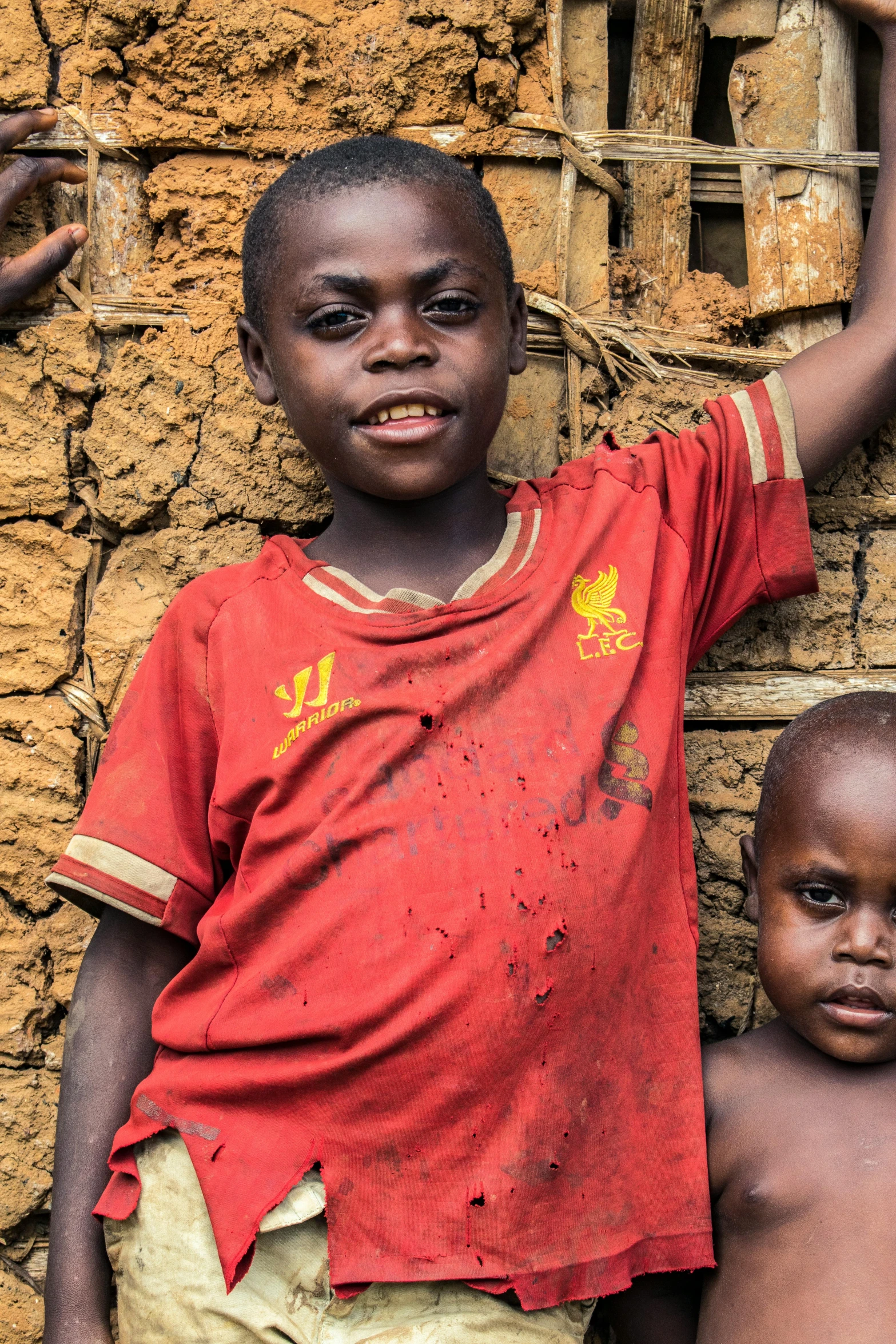 three children are posing in front of a wall