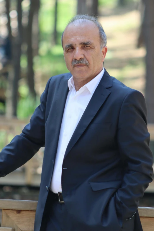 a man in a suit leaning against a railing