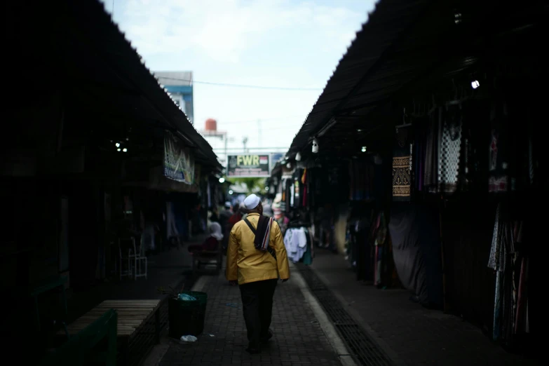 a woman walking down a street lined with lots of buildings