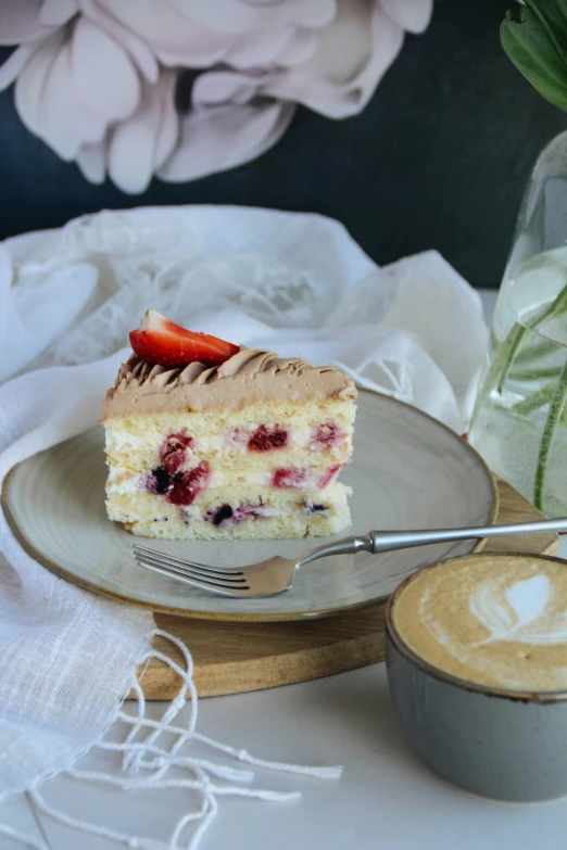 a piece of cake on a plate next to coffee and spoon