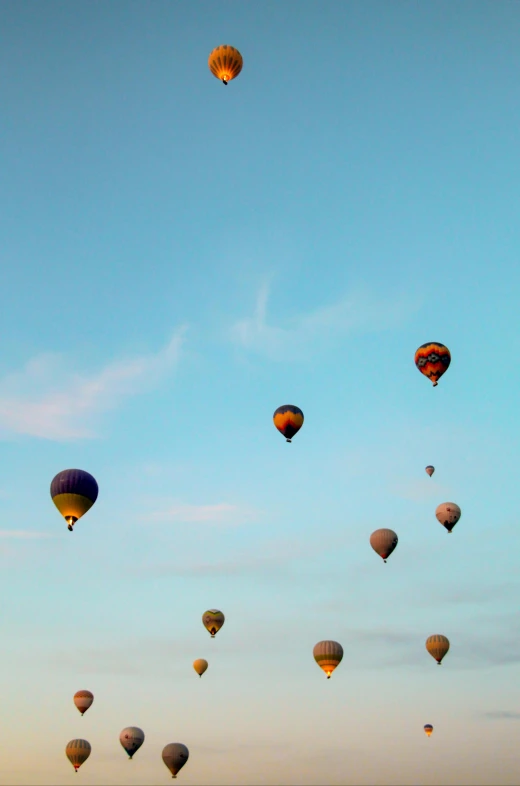 several  air balloons fly through the blue sky