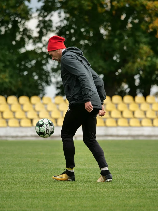 a man in black and red kicks a soccer ball