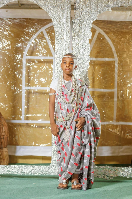 a woman with an oriental style dress standing in front of a curtain