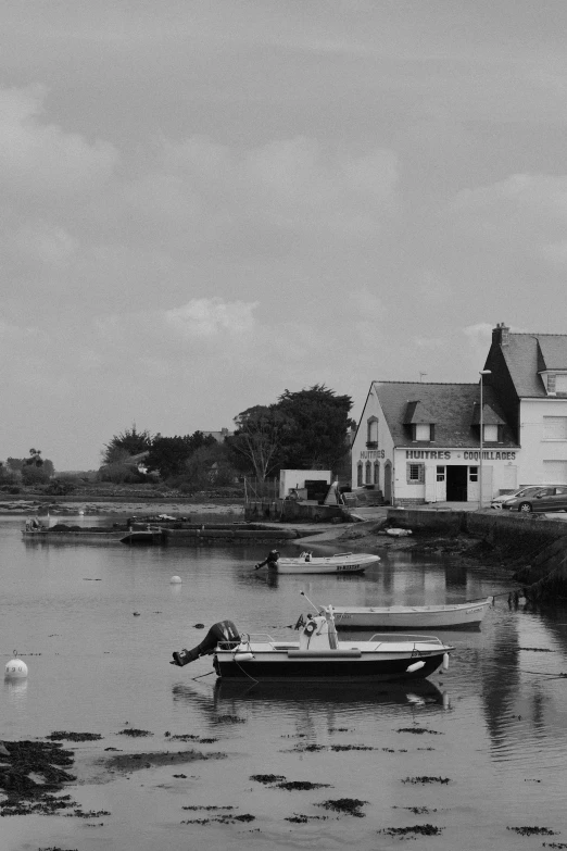 an old black and white po with two small boats