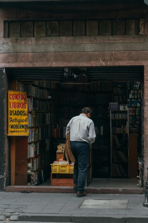 man looking into the doorway of a book store