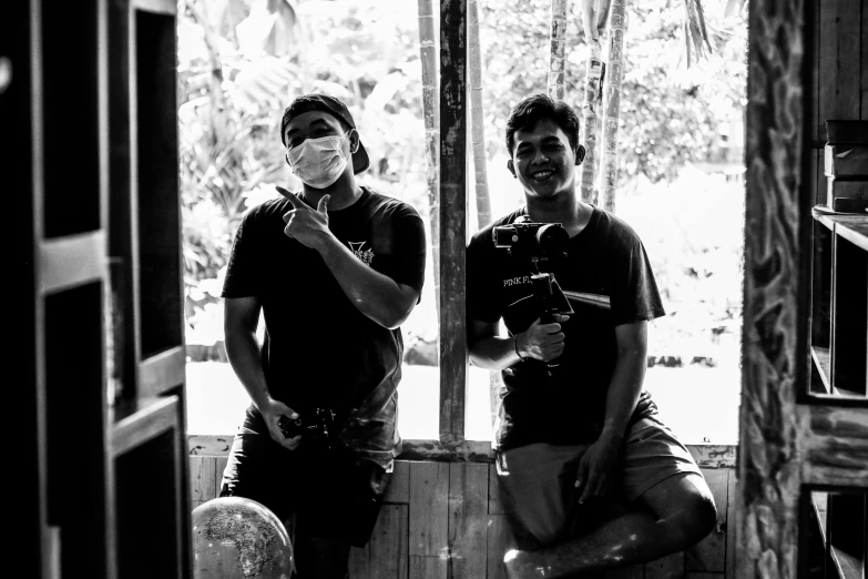 two men wearing masks while sitting on the porch