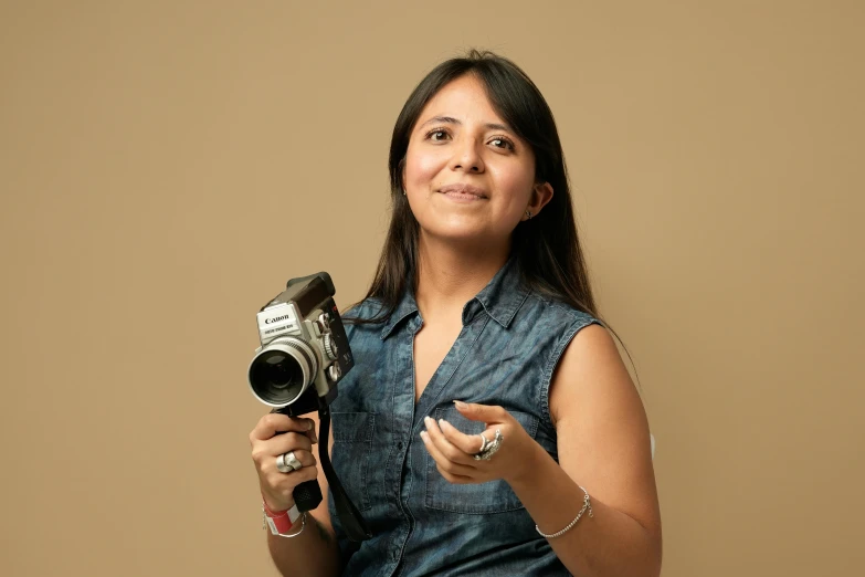 a girl poses with her camera and holds up a bowl