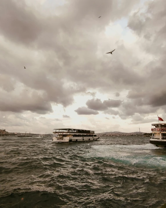 some boats are out on the water under a cloudy sky