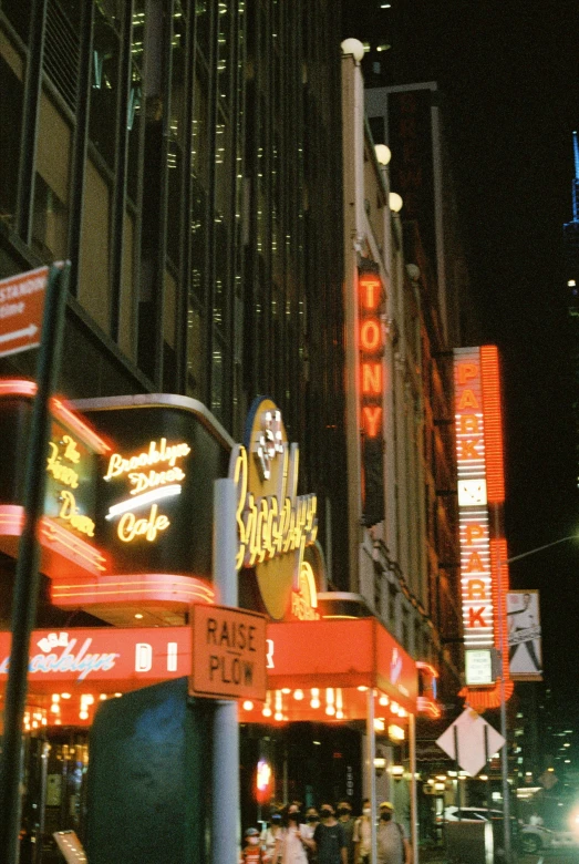 a city intersection at night with neon signs