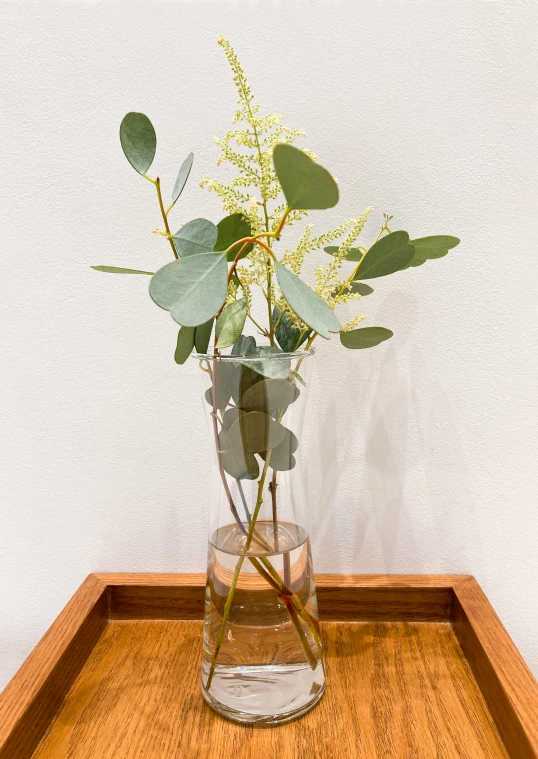 a vase with some green and yellow flowers inside