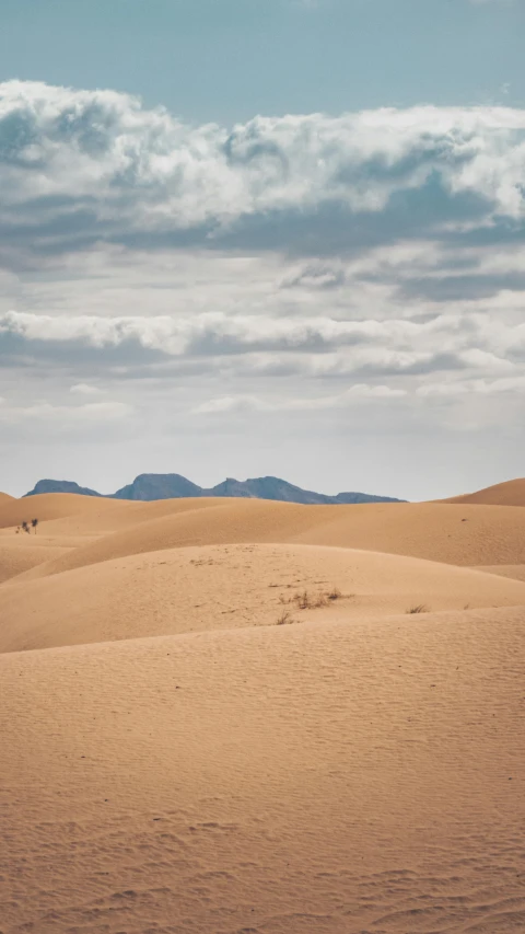 there are many clouds over the horizon above desert landscape